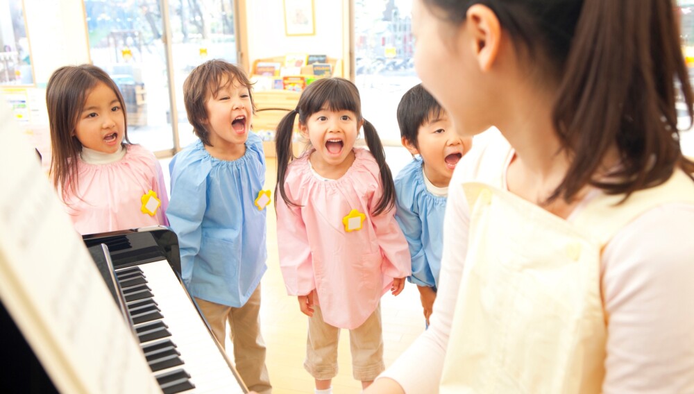 ピアノを弾く保育士と園児たち